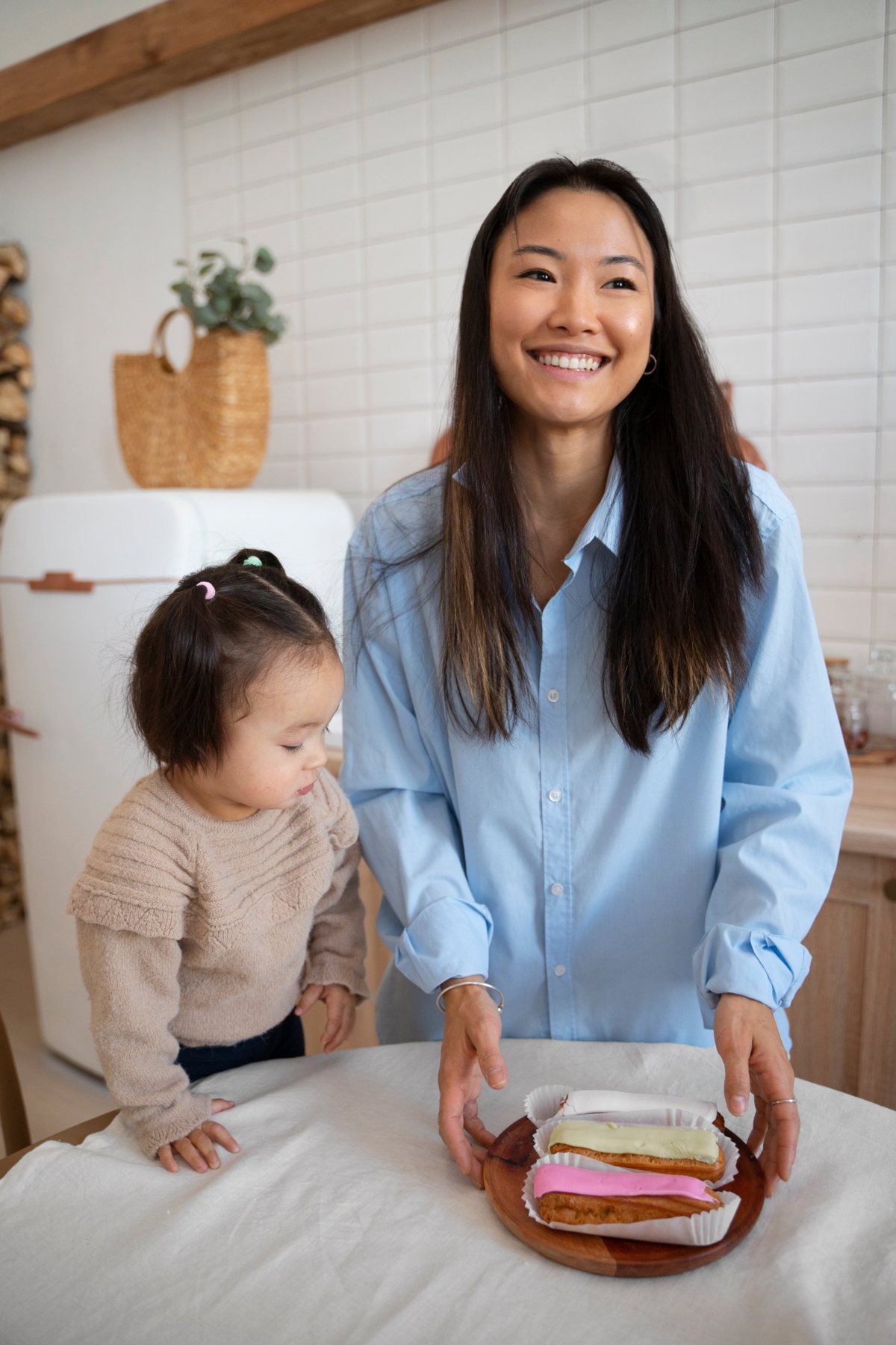 A smiling woman and a toddler at a kitchen table